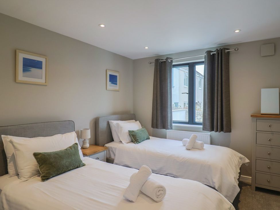 A bedroom with two beds and a window at Wagtail Cottage Lyme Regis