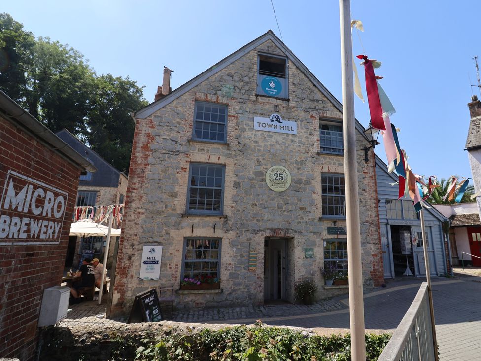 An outdoor scene featuring Town Mill building with microbrewery sign in Lyme Regis