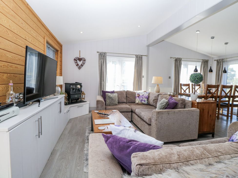 A living room with a sofa and television at Angel Lodge - No 27 Fornham St Genevieve near Bury St Edmunds