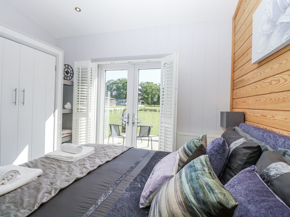 A bedroom with bed and wardrobe at Angel Lodge - No 27, Fornham St Genevieve near Bury St Edmunds