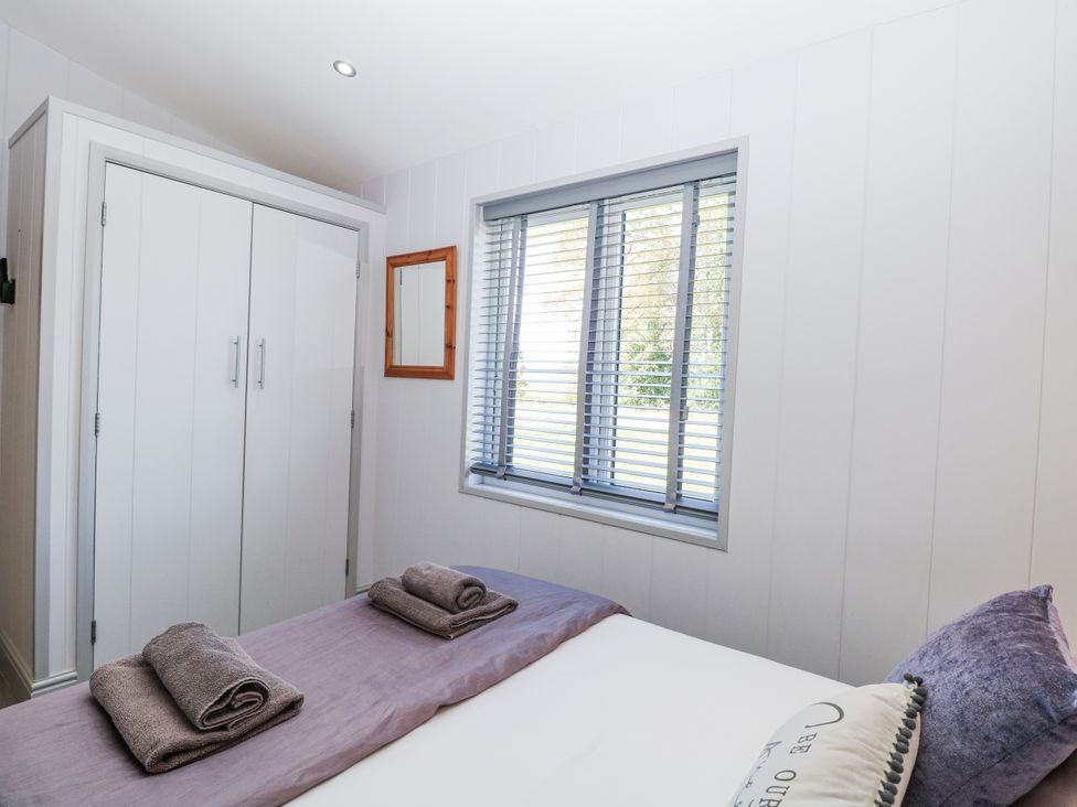 A bedroom with a bed and wardrobe at Angel Lodge - No 27, Fornham St Genevieve near Bury St Edmunds