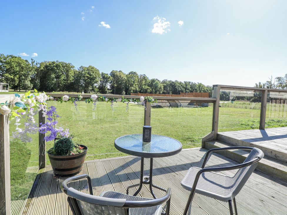 An outdoor seating area with a table and chairs at Angel Lodge - No 27 Fornham St Genevieve near Bury St Edmunds