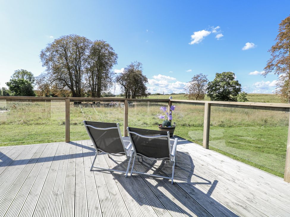 An outdoor area with chairs on a deck at Angel Lodge - No 27 in Fornham St Genevieve near Bury St Edmunds