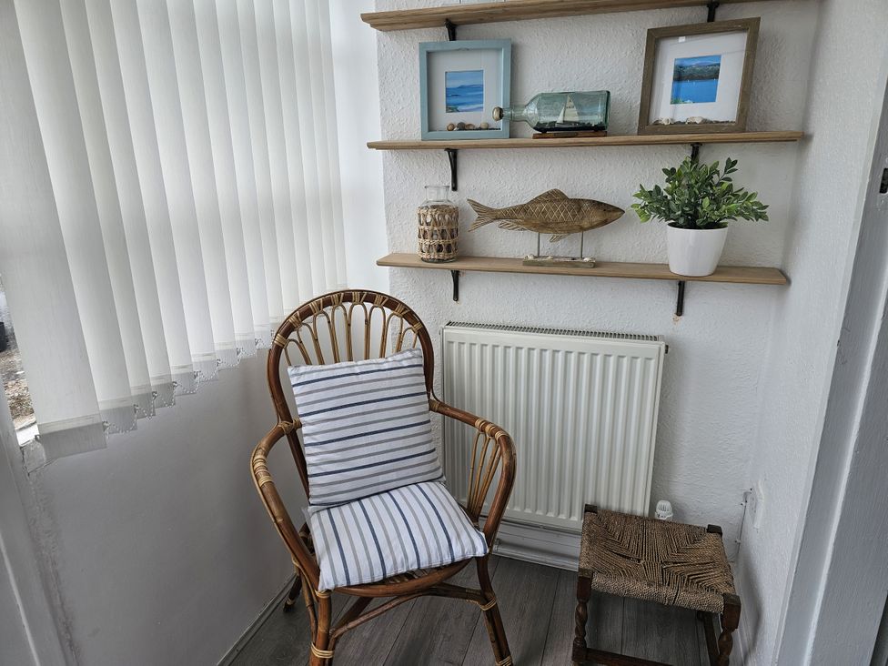 A snug area with a chair and shelf displayed with decorations at Seahorses