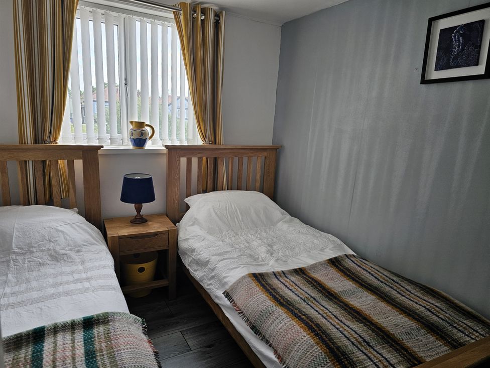 A bedroom with two beds and a window at Seahorses