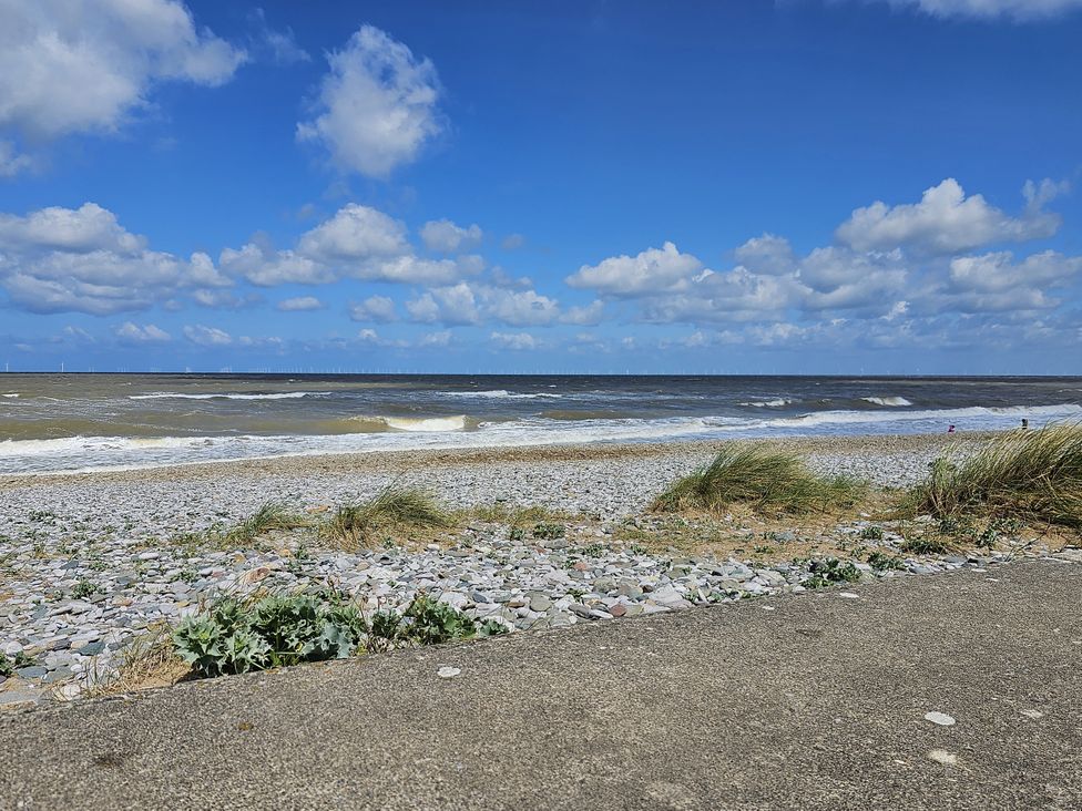 A beach scene with pebbles and waves at Seahorses in Kinmel Bay