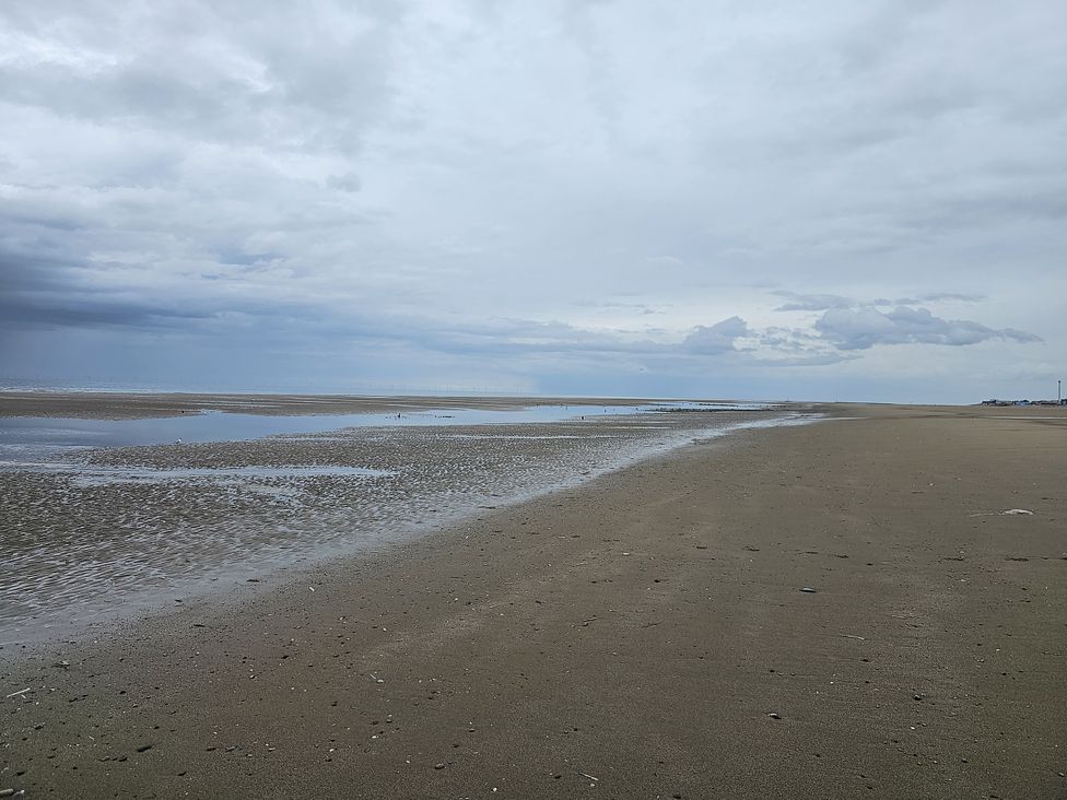 A beach with sand and water at Seahorses in Kinmel Bay