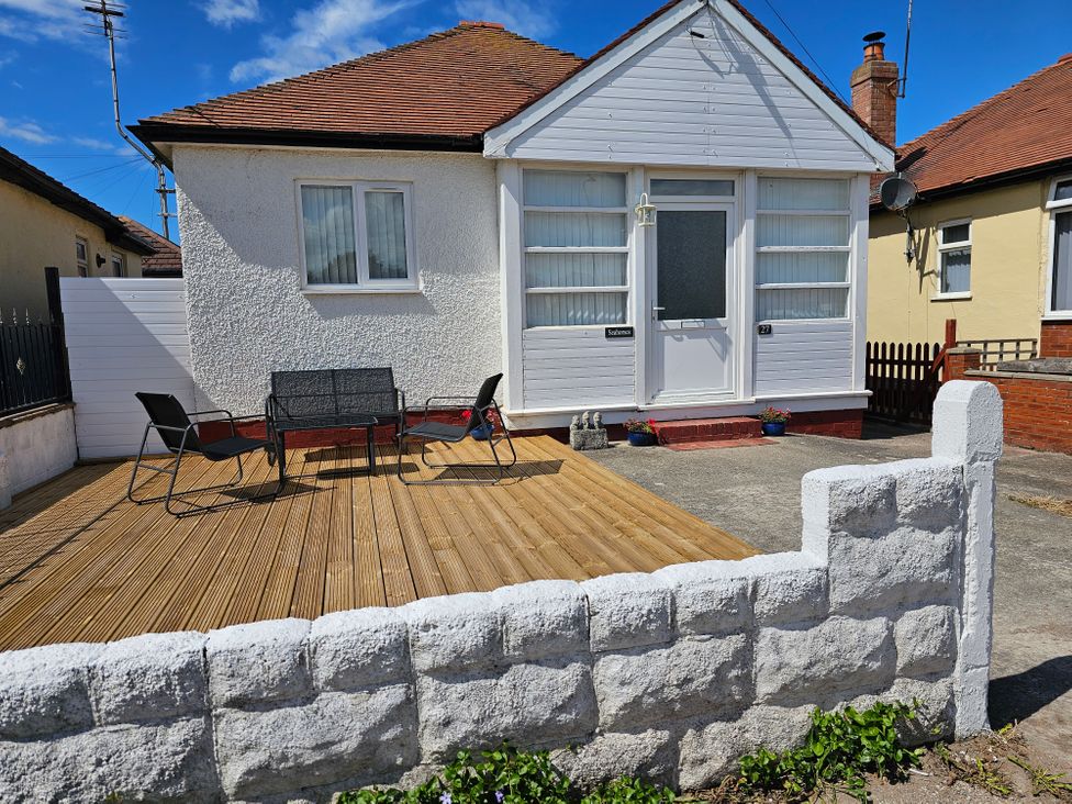 An outdoor area with chairs and decking at Seahorses in Kinmel Bay