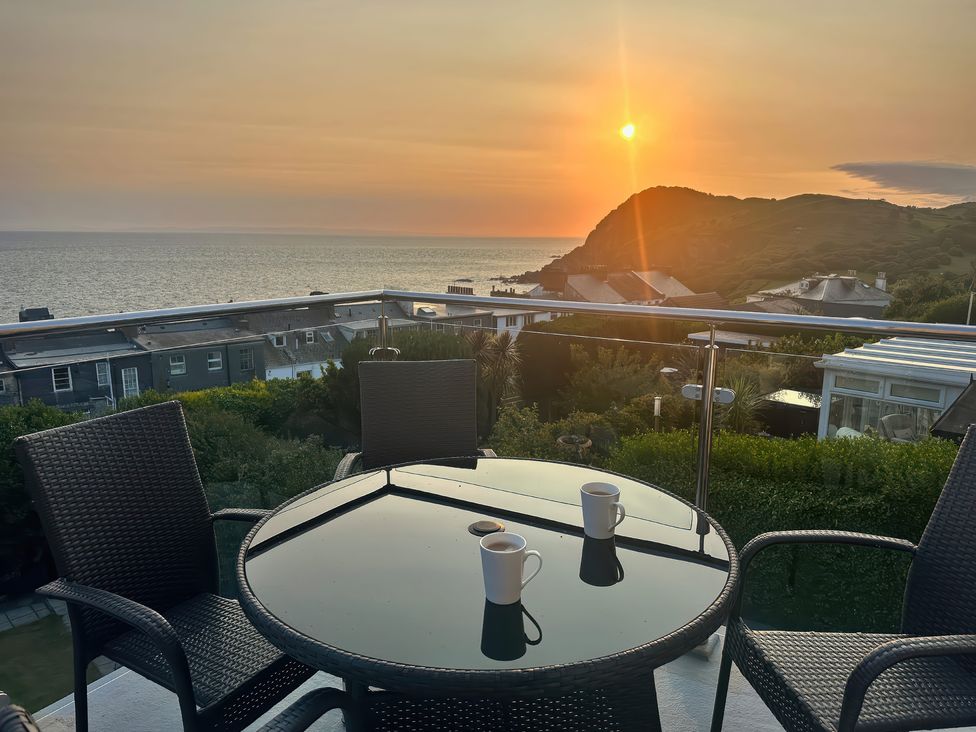 A table and chairs with mugs overlooking the sea at Combe View in Ilfracombe