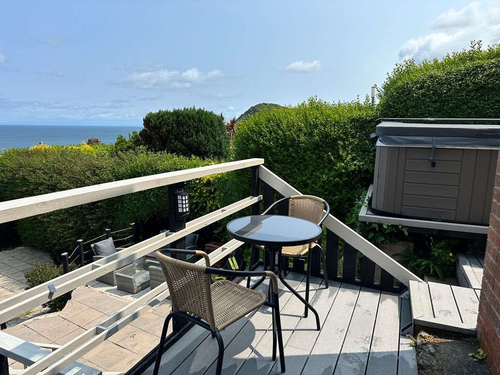 A patio with a table and chairs overlooking the sea at Combe View, Ilfracombe