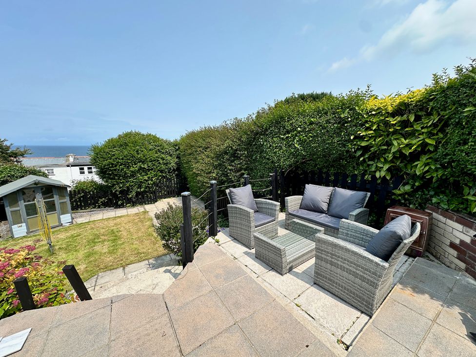 A garden with a seating area and a shed at Combe View in Ilfracombe