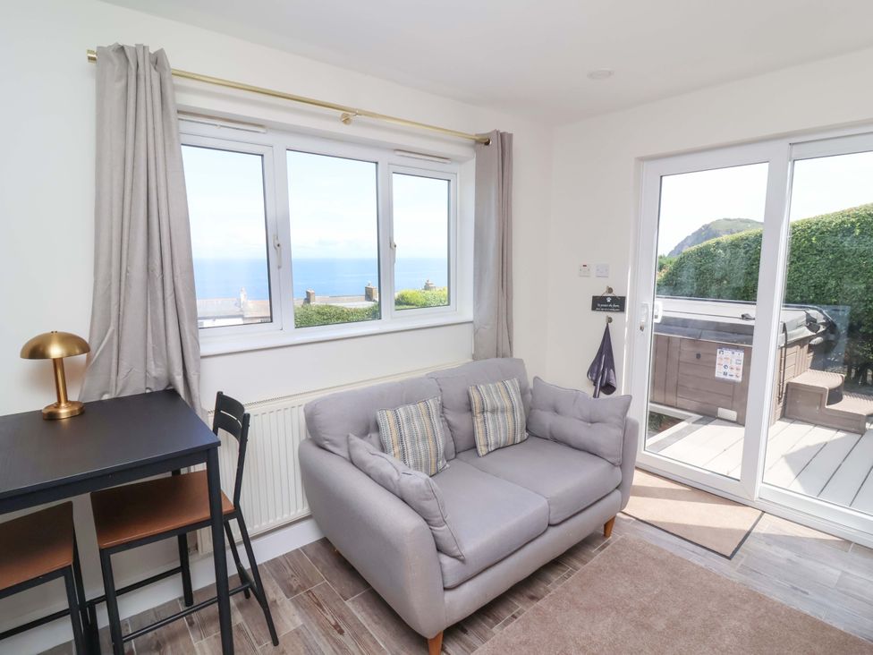 A living room with a sofa and table at Combe View in Ilfracombe
