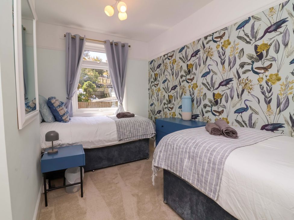 A bedroom with two beds and a window at Combe View in Ilfracombe