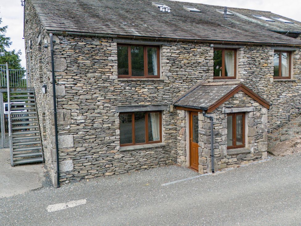 An outdoor view of a stone building with windows and stairs at Rockside At Pound Farm Crook near Kendal