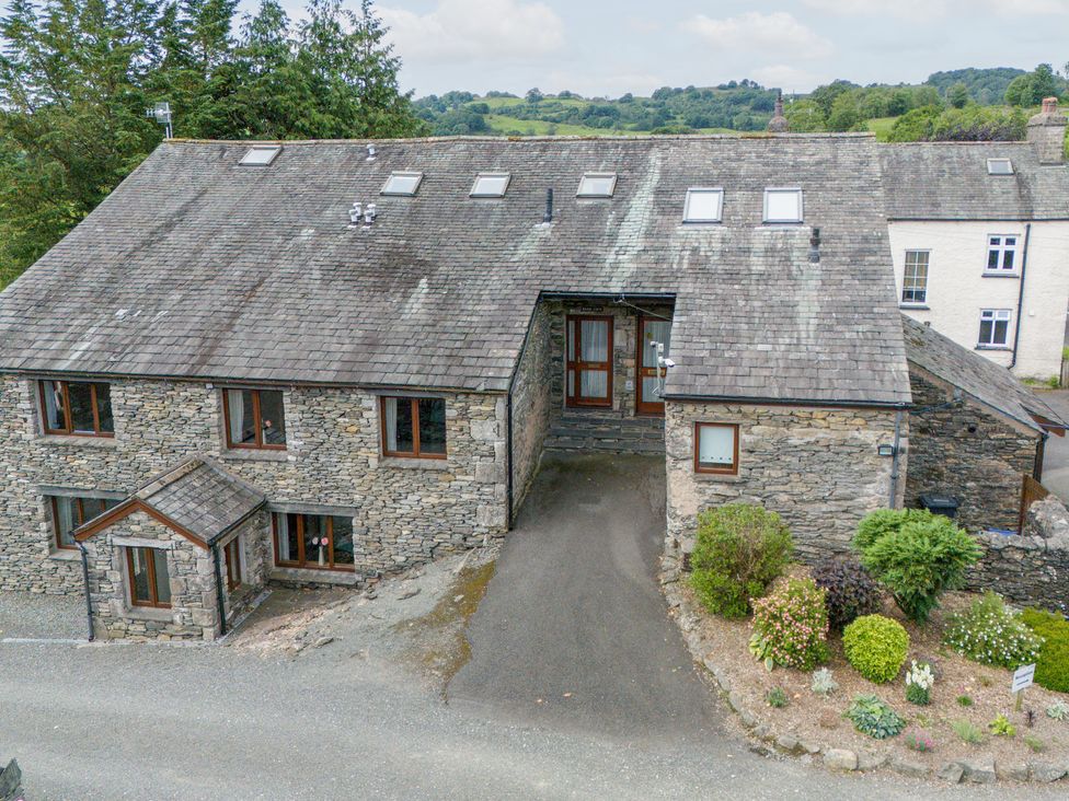 An outdoor view of a stone building with a garden at Bank Barn At Pound Farm Crook near Kendal