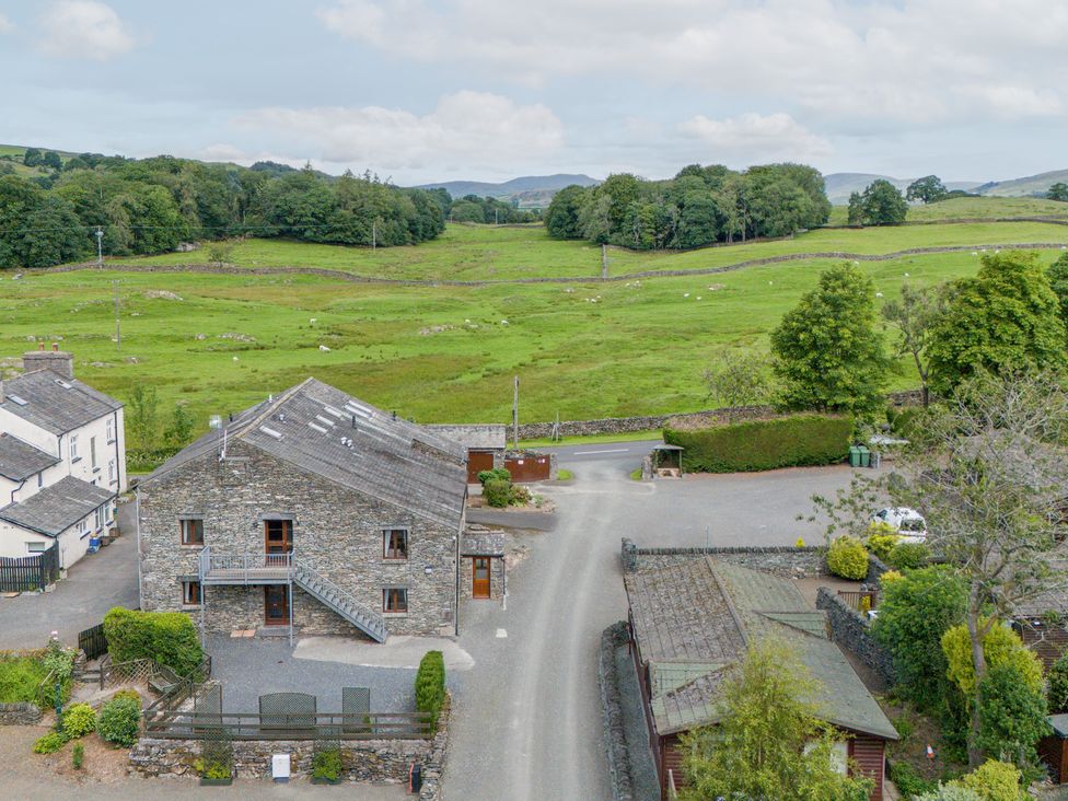 An outdoor view of a stone building and surrounding landscape at Bank Barn At Pound Farm Crook near Kendal