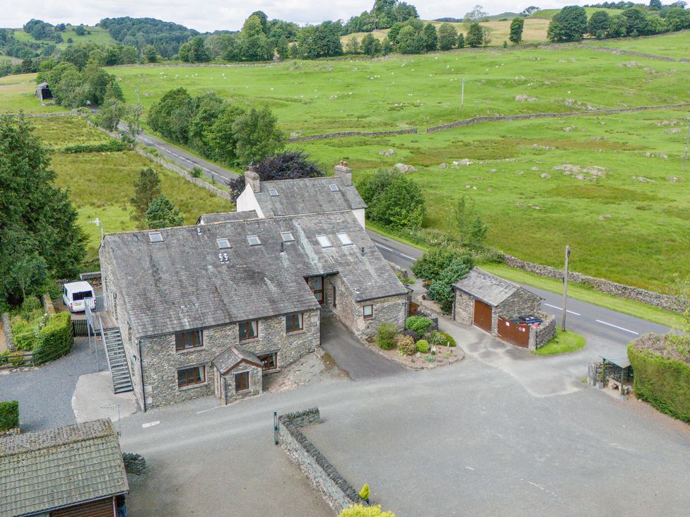 An exterior view of a house surrounded by green fields at Bank Barn At Pound Farm in Crook near Kendal