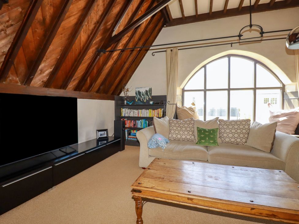 A living room with a couch and bookshelf at The Old Village Chapel in Crantock