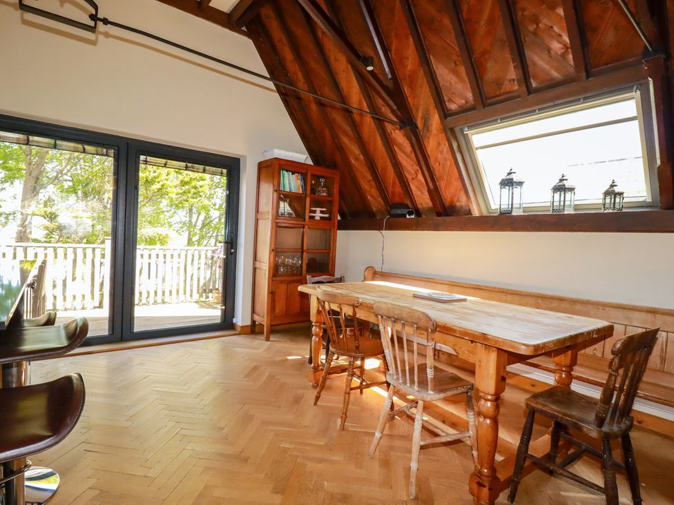 A dining room with a wooden table and chairs at The Old Village Chapel in Crantock