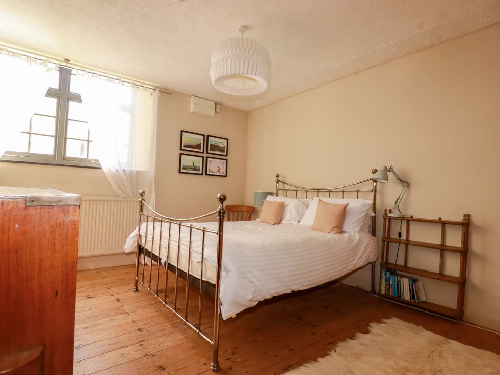 A bedroom with a bed and shelf at The Old Village Chapel in Crantock