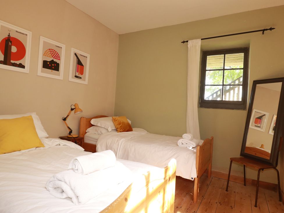 A bedroom with two beds and wall art at The Old Village Chapel in Crantock