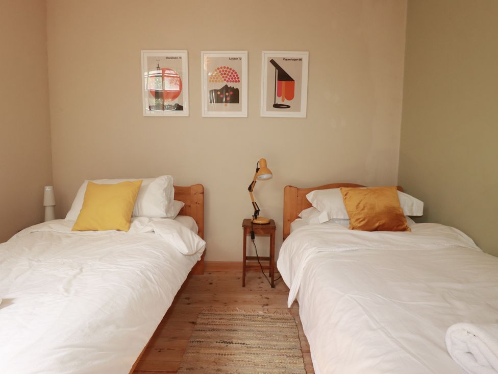 A bedroom with two single beds and posters on the wall at The Old Village Chapel Crantock