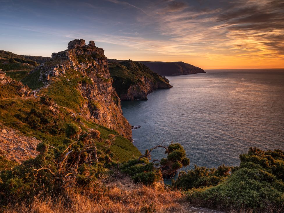 A cliff overlooking the sea during sunset at 23 Manleigh Park in Combe Martin