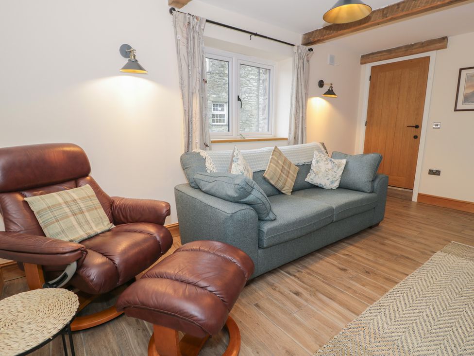 A living room with a sofa and armchair at Y Stabl in Cerrigydrudion