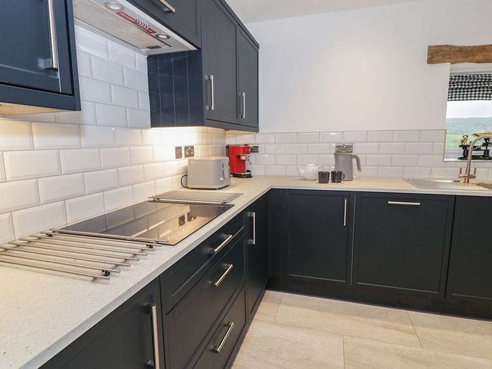 A kitchen with cupboards, stove, sink, and appliances at Y Stabl in Cerrigydrudion