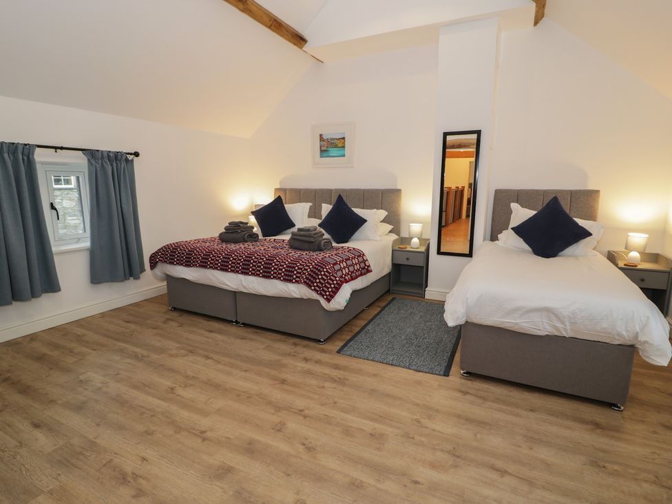 A bedroom with a double bed and single bed at Y Stabl in Cerrigydrudion
