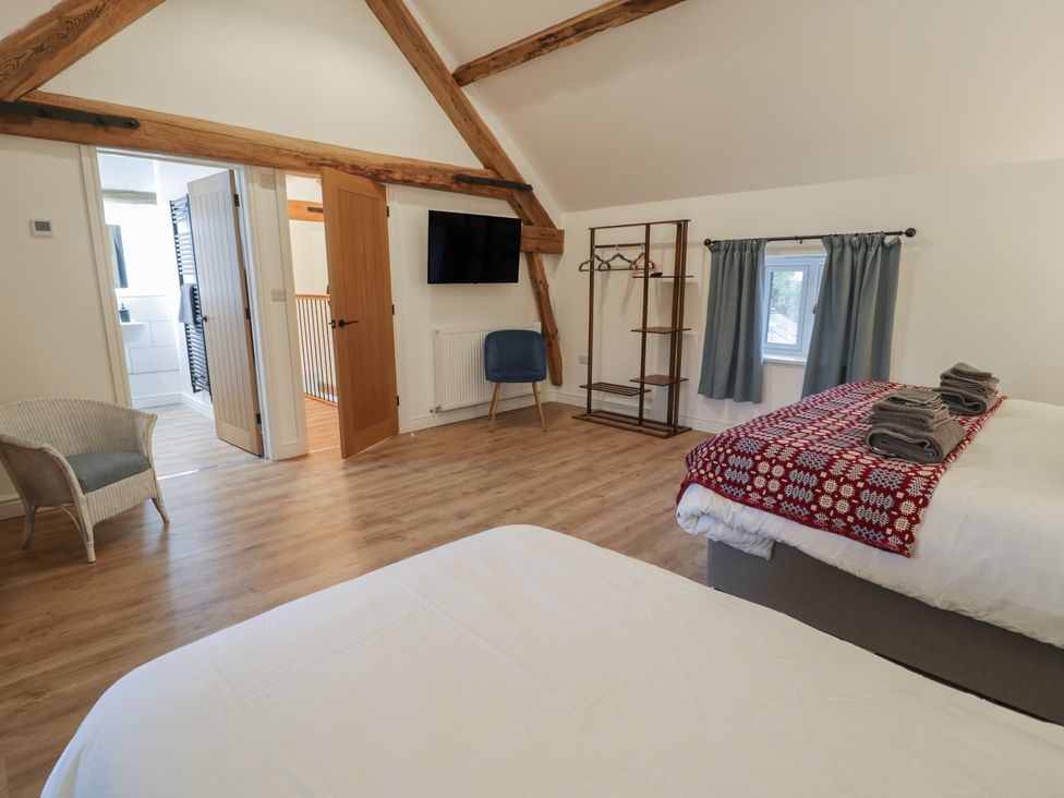 A bedroom with two beds and a television at Y Stabl in Cerrigydrudion