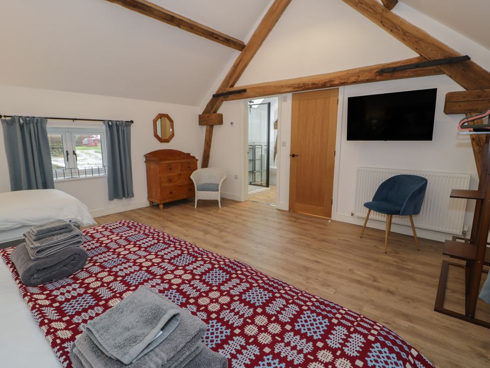 A bedroom with a bed and dresser at Y Stabl in Cerrigydrudion