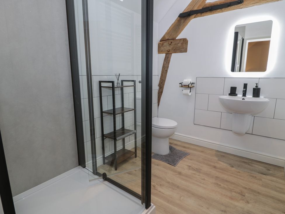 A bathroom with a shower, sink, and toilet at Y Stabl in Cerrigydrudion