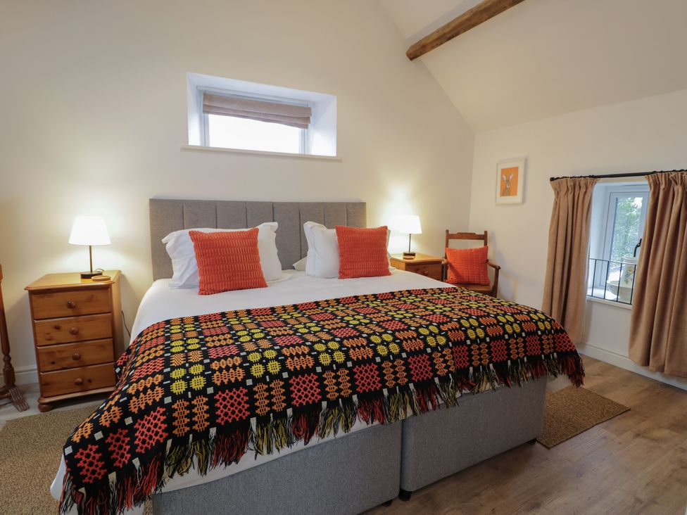 A bedroom with a bed and bedside tables at Y Stabl in Cerrigydrudion