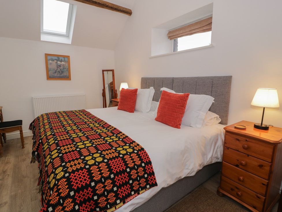 A bedroom with a bed and bedside table at Y Stabl in Cerrigydrudion