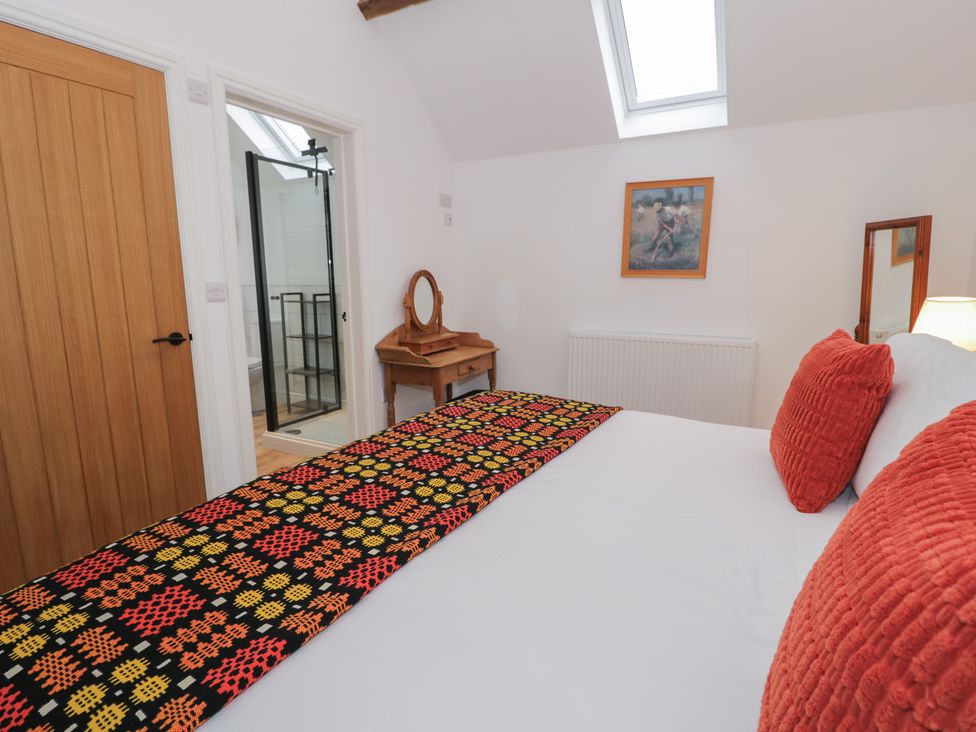A bedroom with a bed and table at Y Stabl in Cerrigydrudion