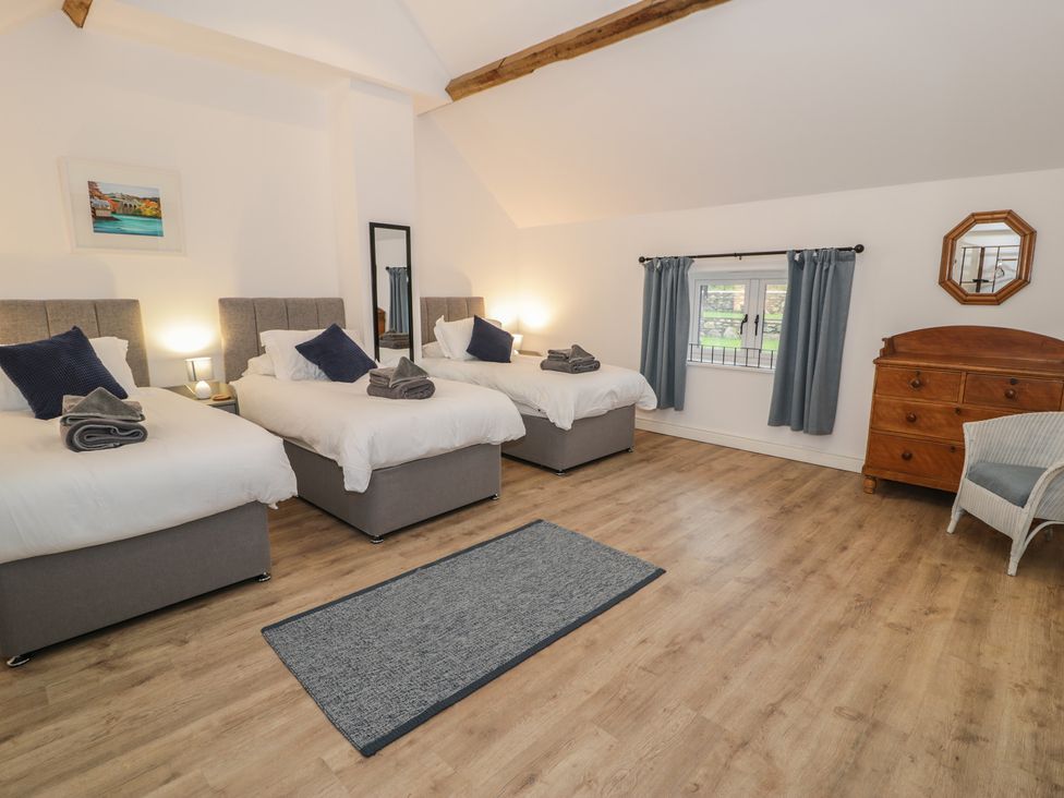 A bedroom with three beds and a dresser at Y Stabl in Cerrigydrudion