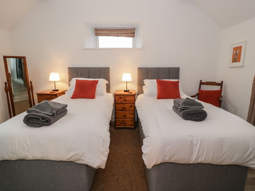 A bedroom with two twin beds and lamps at Y Stabl in Cerrigydrudion