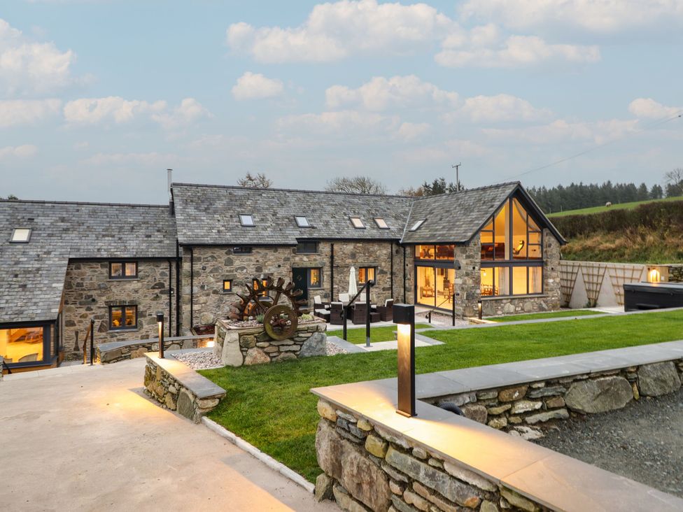 An outdoor view of a house with seating and garden features at Y Stabl in Cerrigydrudion