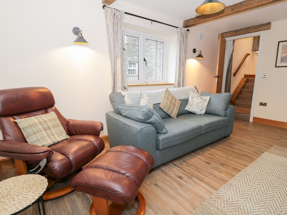 A living room with a sofa and armchair at Y Stabl in Cerrigydrudion