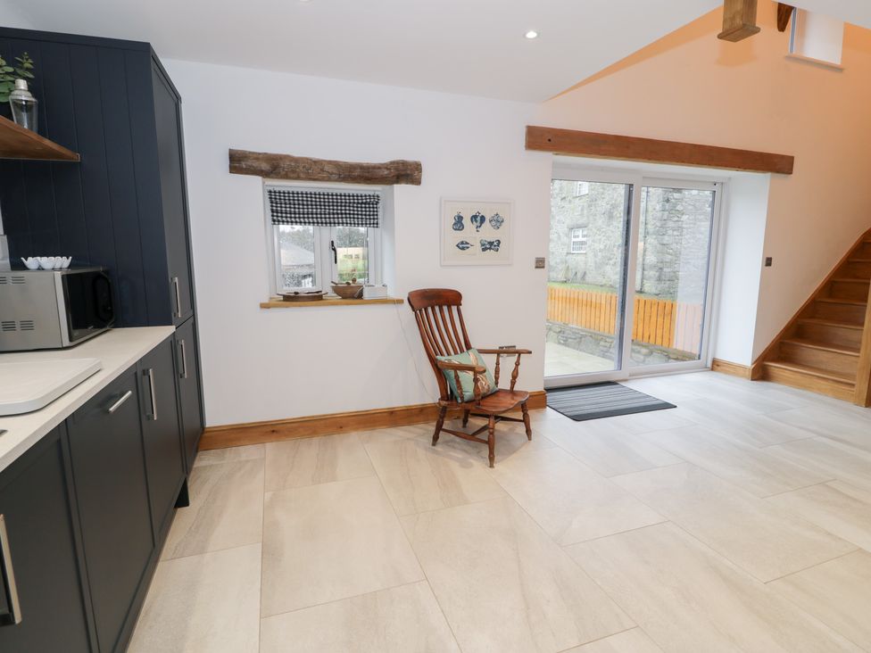 A kitchen with a rocking chair and microwave at Y Stabl in Cerrigydrudion