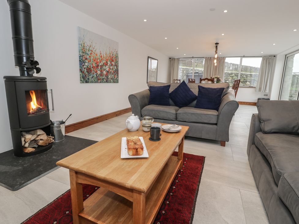 A living room with a fireplace and a coffee table at Y Côr in Cerrigydrudion