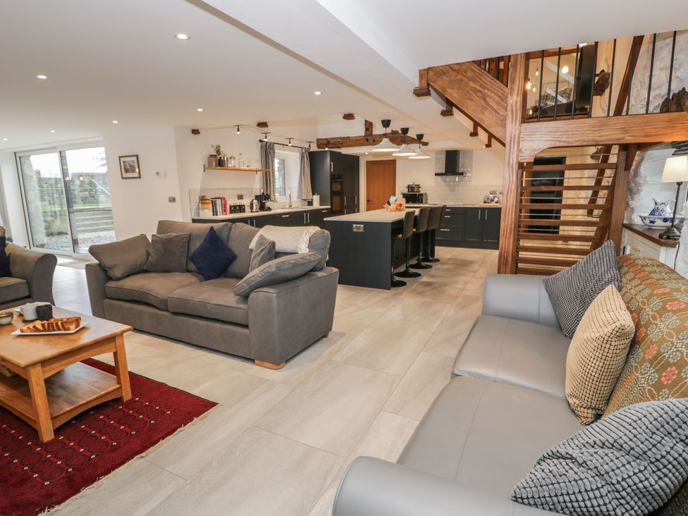A living room with sofas and a kitchen area at Y Côr in Cerrigydrudion