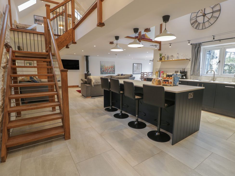 A kitchen with a staircase leading to an upper level at Y Côr in Cerrigydrudion