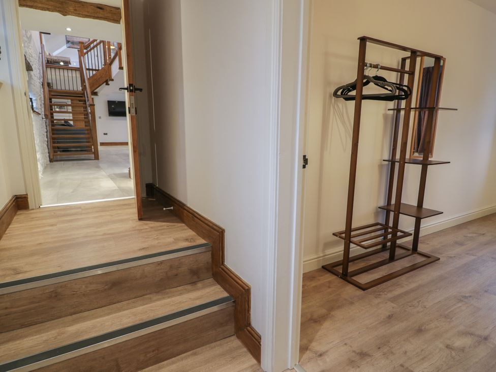A hallway with stairs and a clothes rack at Y Côr in Cerrigydrudion