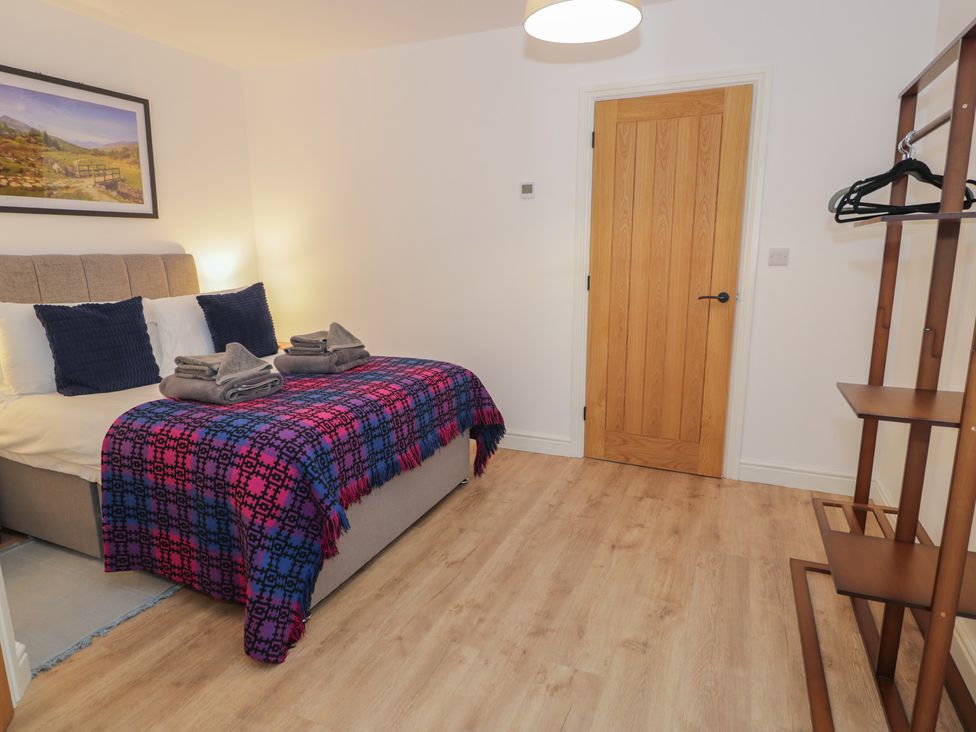 A bedroom with a bed and shelving at Y Côr, Cerrigydrudion