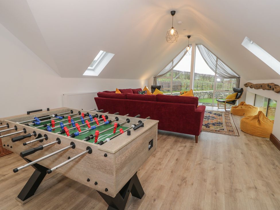 A snug with a foosball table and sofa at Y Côr in Cerrigydrudion