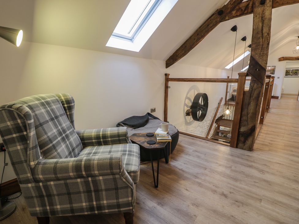 A living room with an armchair and side table at Y Côr in Cerrigydrudion