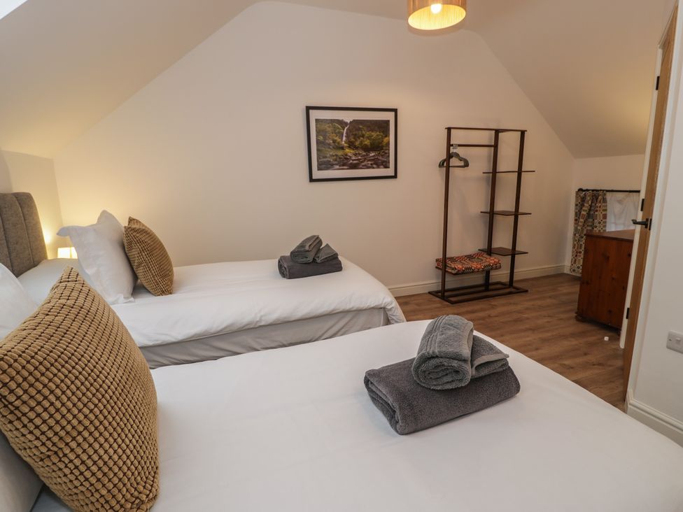 A bedroom with two single beds and a wardrobe at Y Côr in Cerrigydrudion