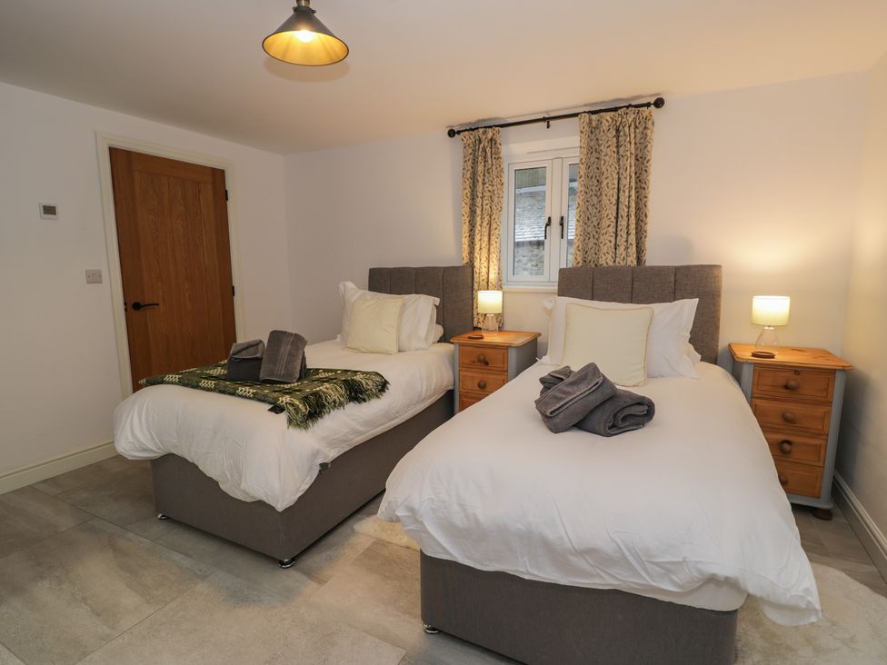 A bedroom with two single beds and bedside tables at Y Côr in Cerrigydrudion
